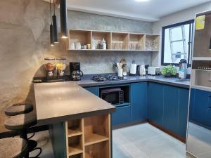 una cucina con armadi blu e piano di lavoro di La escondida house a Medellín