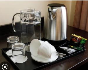 a tray with a coffee pot and plates on a table at The Coastal Inn OUTBUILDING in Cellardyke