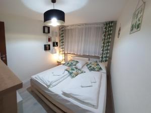 - une chambre avec un lit doté de draps et d'oreillers blancs dans l'établissement Mieszkanie 3 pokojowe Park Chopina, à Świnoujście