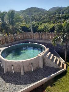a circular pool with stairs around it with mountains in the background at Casa Camilla in Las Galeras