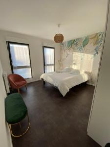 - une chambre avec un grand lit et une chaise dans l'établissement Charmante maison de ville 4 chambres proche de Paris, à Chevilly-Larue