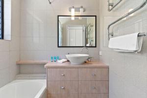 a bathroom with a sink and a tub and a mirror at Rayner's Secret in Lennox Head +24 photos
