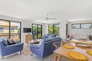 a living room with blue couches and a table at Rayner's Secret in Lennox Head