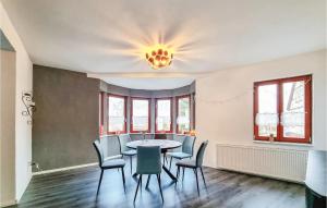 a dining room with a table and chairs and a chandelier at 2 Bedroom Cozy Apartment In Kltze in Klötze