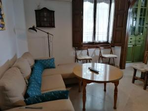 ein Wohnzimmer mit einem Sofa und einem Tisch in der Unterkunft Casa Rural Torre del Agua. Un lugar con encanto. in Osuna