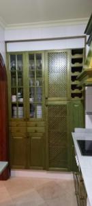 una cocina con un armario verde con puertas de cristal en Casa Rural Torre del Agua. Un lugar con encanto., en Osuna