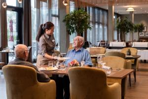 dos personas sentadas en una mesa en un restaurante en Senevita Dorfmatt Ferienwohnungen und Apartments en Münsingen