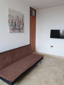 Sofá marrón en una habitación con TV en Departamento-Mamá Feli M5, en Chiclayo