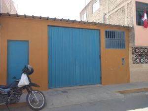 una motocicleta estacionada frente a dos puertas de garaje en Departamento-Mamá Feli M5, en Chiclayo