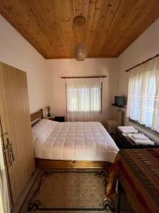 a bedroom with a large bed with a wooden ceiling at Sweet home in Kalavrita