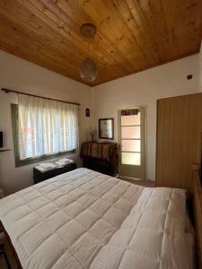 a bedroom with a large bed with a wooden ceiling at Sweet home in Kalavrita