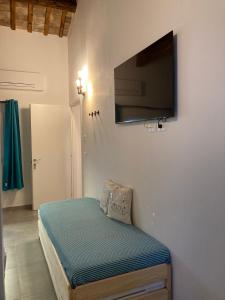 1 dormitorio con 1 cama y TV de pantalla plana en la pared en AL RUDERINO, en Comacchio