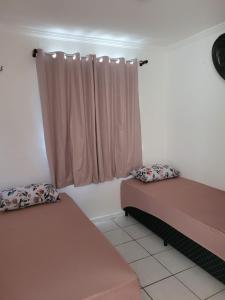 2 Betten in einem Zimmer mit Fenster in der Unterkunft Apartamento Tupy I - Turu in São Luís