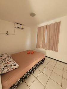 Habitación pequeña con cama con zapatillas rojas. en Apartamento Tupy I - Turu, en São Luís