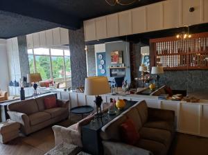 a living room with two couches and a kitchen at Vista Do Vale in Furnas