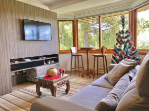 una sala de estar con un árbol de Navidad y un sofá en Apartamentos Lagos de Gramado by Achei Gramado, en Gramado