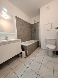 La salle de bains est pourvue d'une baignoire, de toilettes et d'un lavabo. dans l'établissement Charmante maison de ville 4 chambres proche de Paris, à Chevilly-Larue