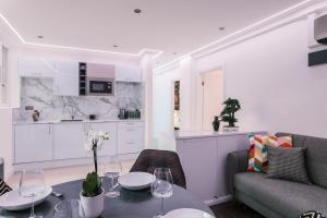een keuken en een woonkamer met een tafel en een bank bij WelcomeStay Fitzrovia Two Bed Apartments - Sleep in Opulent Luxury in Londen