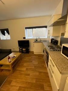 a kitchen with a table and a counter top at Spacious sofa bed lounge area with ensuite bedroom in Wednesbury