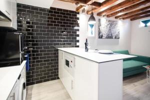 cocina con encimera blanca y pared de ladrillo negro en Fantastic flat in Call-Preciados-Gran Vía 4P, en Madrid