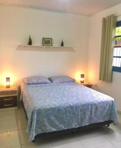 um quarto com uma cama com um edredão azul em Morada Santa Pinheira em Palhoça
