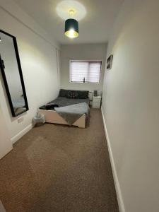 a bedroom with a bed and a window at Spacious sofa bed lounge area with ensuite bedroom in Wednesbury