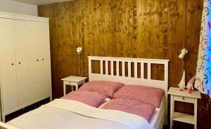 um quarto com uma cama e uma parede de madeira em Chalupa 96 em Víchová nad Jizerou