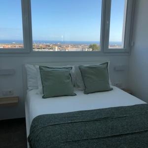 Cama en habitación con 2 ventanas grandes en Blanco Homes & Living 3B, en El Tablero