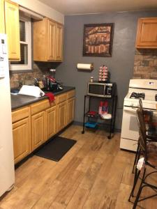 uma cozinha com armários de madeira e um frigorífico branco em Cuddys Place em Pittsburgh