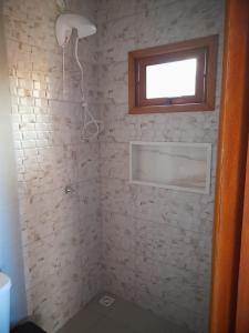 a bathroom with a shower with a window at Residencial Aracuã Praia Brava in Itajaí
