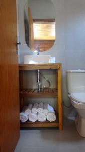 a bathroom with a sink and a bunch of towels at Residencial Aracuã Praia Brava in Itajaí