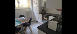 - une petite cuisine avec une table, des chaises et un comptoir dans l'établissement Renovierte Ferienwohnung im Zentrum von Locarno, à Locarno