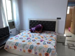 a bedroom with a bed with a floral comforter at Shri Vasudev Farms 