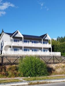 uma grande casa branca com uma cerca em frente em Bahia Rooms em El Calafate