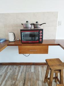 Un horno tostador con dos ollas encima. en Bahia Rooms en El Calafate