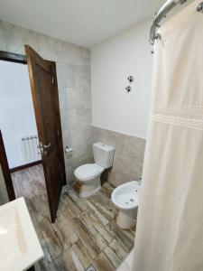 uma casa de banho com um WC e um lavatório em Bahia Rooms em El Calafate