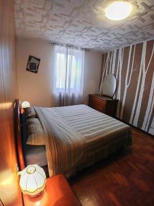 een slaapkamer met een bed, een tafel en een raam bij da Stoimenov in Fondo