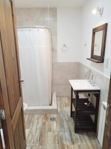 uma casa de banho com uma banheira, um lavatório e um chuveiro em Bahia Rooms em El Calafate