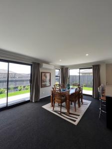 a dining room with a table and chairs and large windows at Beautifully presented home in Richmond