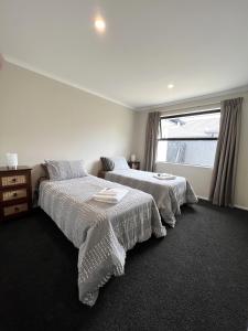 1 dormitorio con 2 camas y ventana en Beautifully presented home, en Richmond