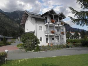 a large white building with flowers on the balconies at Appartementhaus Kraker in Presseggersee