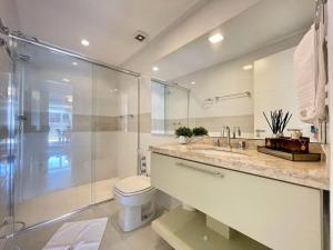 y baño con ducha, aseo y lavamanos. en Apartamentos Dom Rolim no CENTRO by Achei Gramado, en Gramado