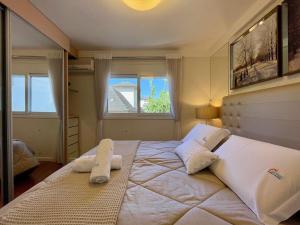 een slaapkamer met een groot bed met 2 kussens erop bij Apartamentos Dom Rolim no CENTRO by Achei Gramado in Gramado