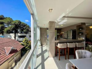 a balcony of a house with a view of a kitchen at Apartamentos Dom Rolim no CENTRO by Achei Gramado in Gramado