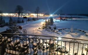 a view of a snow covered yard at night at Motel Jaśminowy Dworek Człekówka 67 B in Człekowka