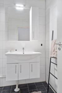 a white bathroom with a sink and a mirror at Charming, Central, Coffee Machine in Ålesund