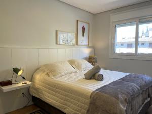 um quarto com uma cama, uma mesa e uma janela em Apartamentos L'adress Reserve CENTRO by Achei Gramado em Gramado