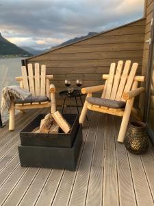 two wooden chairs and a table on a deck at Ocean View Stad in Barmen