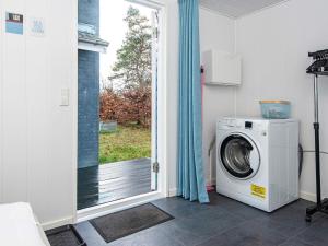 RøndeにあるHoliday home Rønde XXIVの窓付きの客室で、洗濯機が備わります。