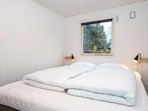 2 camas en una habitación blanca con ventana en Holiday home Rønde XXIV, en Rønde